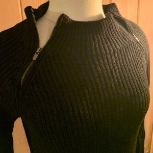 Zip-neck black ribbed sweater.